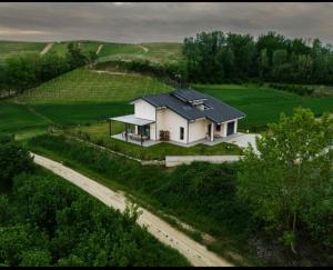 a white house with a black roof on a road at Maison du Mathilda in Santo Stefano Roero