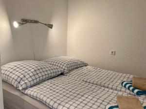 ヴァンガーオーゲにあるHaus Panorama 2の壁にライトが付くベッドルームの小さなベッド1台