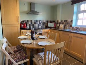 una cocina con una mesa de madera con copas de vino. en 3 Bedroom Cottage Sleeps 5 village location en Scarborough