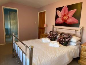 1 dormitorio con 1 cama con una gran flor rosa en la pared en 3 Bedroom Cottage Sleeps 5 village location en Scarborough