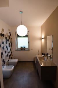 y baño con lavabo, aseo y espejo. en Maison du Mathilda en Santo Stefano Roero
