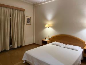 a bedroom with a white bed and a window at Grande Hotel Dom Dinis in Mirandela