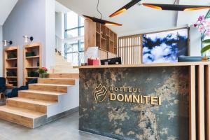 a lobby with stairs and a sign that reads hospital donut center at Hotel Domnitei in Călimăneşti