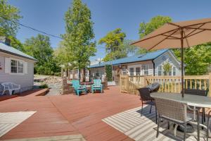 eine Terrasse mit Tisch und Stühlen und einem Sonnenschirm in der Unterkunft Cozy Mountain Home Cottage Walk to Marina! in Mountain Home