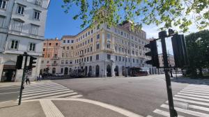 a large white building on a city street with a crosswalk at Le Saline Luxury Guest House in Trieste