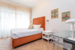 a bedroom with a bed and a glass table at Daplace - Gran Torino Suites in Rome