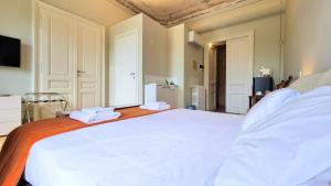 a bedroom with a large white bed with white sheets at Le Saline Luxury Guest House in Trieste