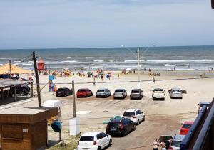 a group of cars parked on a beach with people at Hotel Mariluz in Imbé