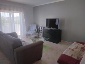 un soggiorno con divano e TV di Appartement à LOURINHA - 1er étage a Lourinhã