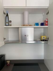 a kitchen with white shelves and a bottle of wine at LAKE in Lugano