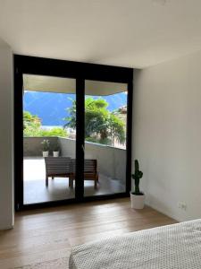 a bedroom with a sliding glass door with a bench at LAKE in Lugano