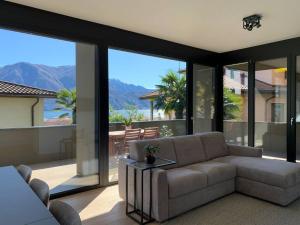 uma sala de estar com um sofá e grandes janelas de vidro em LAKE em Lugano