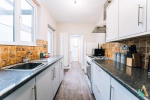 a kitchen with white cabinets and a sink at Trent House TSAC in Stockton-on-Tees