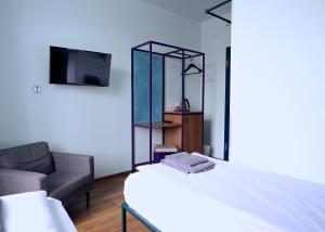 a bedroom with a bed and a chair and a mirror at Das Schreder Hotel in Munich