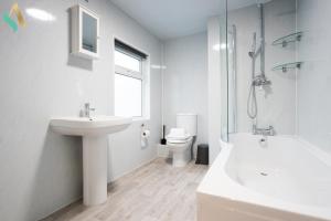 uma casa de banho branca com um lavatório e um WC em Trent House TSAC em Stockton-on-Tees