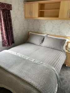 a bedroom with a white bed with a wooden headboard at The Rock Bar B&B in Kilkenny
