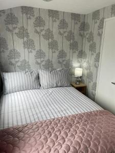a bedroom with a large bed with a bedspread on it at The Rock Bar B&B in Kilkenny