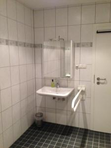 a white bathroom with a sink and a mirror at Alte Rose Gasthaus in Ebelsbach