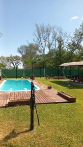 una pequeña piscina con terraza de madera junto a un campo en El Colibrí 1 en Arroyo Seco