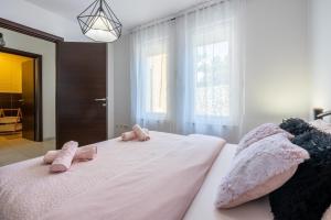 - une chambre avec des animaux farcis roses sur un lit dans l'établissement Marie, à Crikvenica