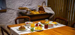 einem Holztisch mit Teller mit Lebensmitteln darauf in der Unterkunft Quinta de Chousas - Braga - Agroturismo in Braga