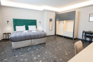 a bedroom with a large bed and a table at City Life Athens Apartments in Athens