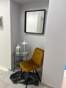 uma cadeira amarela e uma mesa com um espelho em SKY HOUSE LUXURY em Nápoles