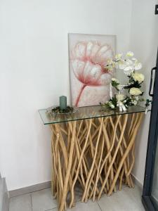 uma mesa de consola com uma tampa de vidro e flores sobre ela em SKY HOUSE LUXURY em Nápoles