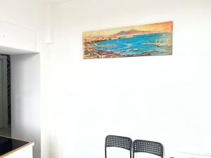 duas cadeiras numa cozinha com um quadro na parede em SKY HOUSE LUXURY em Nápoles