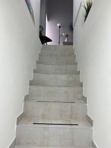 uma escada numa casa com paredes brancas em SKY HOUSE LUXURY em Nápoles