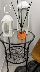 una mesa de cristal con una linterna y un jarrón. en SKY HOUSE LUXURY en Nápoles