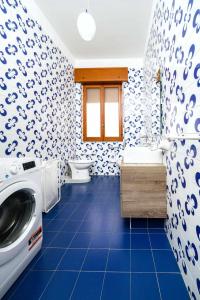 a blue and white bathroom with a washing machine at Casamici Sampieri Centosicilie in Sampieri