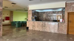 a lobby with a bar and chairs in a building at Grande Hotel Dom Dinis in Mirandela