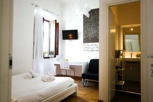a bedroom with a bed and a chair and a window at I'MC IoAMoCagliari in Cagliari