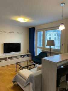 a living room with a couch and a television at ComeWa Apartments in Warsaw