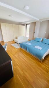 a large bedroom with a large bed and wooden floors at Villa Sunny Side Skopje in Dolno Solnje