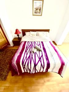 uma cama com um edredão roxo e branco num quarto em RoNi RoOms em Salou