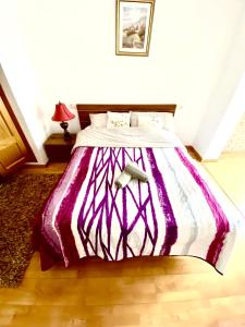 a bed with a purple and white comforter in a bedroom at RoNi RoOms in Salou