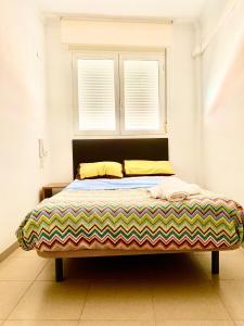 a bed sitting in a room with two windows at RoNi RoOms in Salou