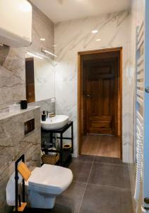 łazienka z toaletą i umywalką w obiekcie Niemirowska Osada w mieście Niemirów