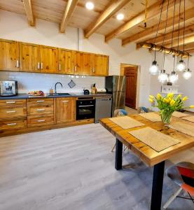 a kitchen with wooden cabinets and a wooden table at Niemirowska Osada in Niemirów