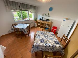 eine Küche mit 2 Tischen und einem Kühlschrank in der Unterkunft Pensión Codesal in O Pedrouzo