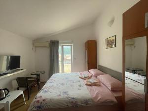 um quarto com uma cama e duas mesas e uma televisão em Apartments Manojlovic em Budva