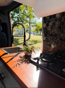 a kitchen counter with a sink and a stove at BeeVan in Aguadilla