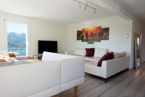 un soggiorno bianco con divano e TV di Casa Bellavista a Pugerna