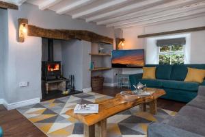 a living room with a couch and a fireplace at Farmhouse & exclusive outdoor heated pool in Bryn-crug