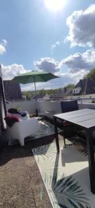 een patio met een tafel en stoelen en een parasol bij Kissinger38 in Detmold