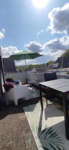 Un patio con una mesa y sillas y una sombrilla. en Kissinger38, en Detmold