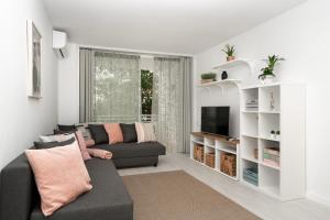 ein Wohnzimmer mit Couch und Fernseher in der Unterkunft Apartment Bitacora FULLY RENOVATED 2023 in Lloret de Mar