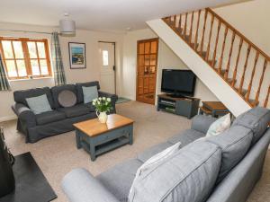 a living room with a couch and a tv at Ty Rhosyn in Haverfordwest